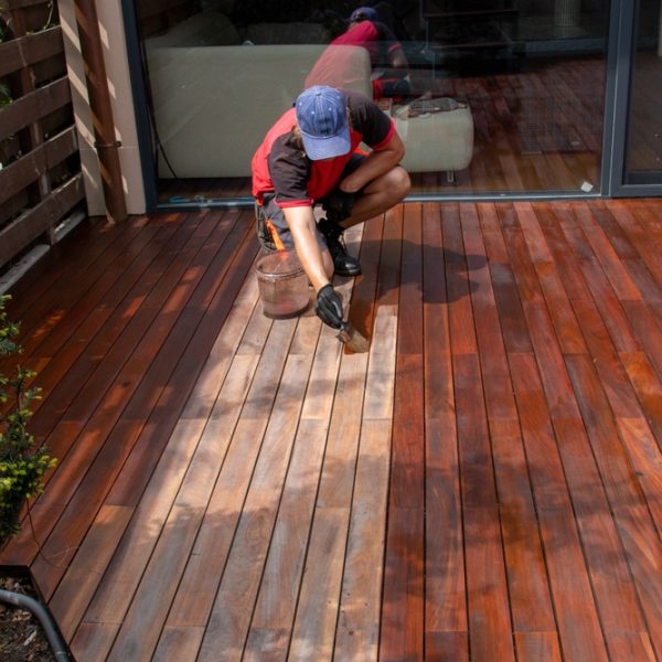 Wood,Worker,Applying,Nourishing,Deck,Oil,With,Paintbrush,On,Cleaned